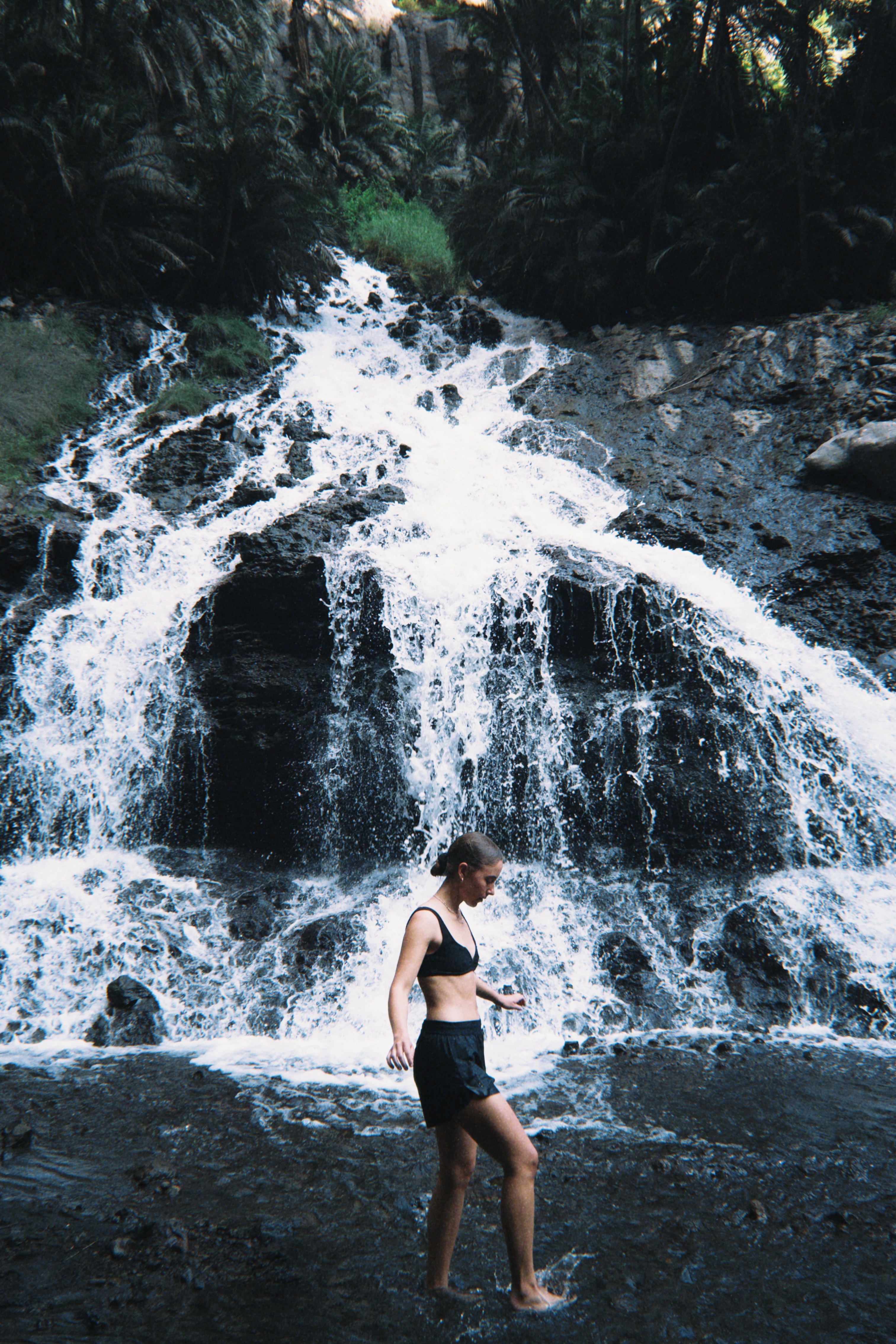 Traveler wading near a waterfall in Tanzania