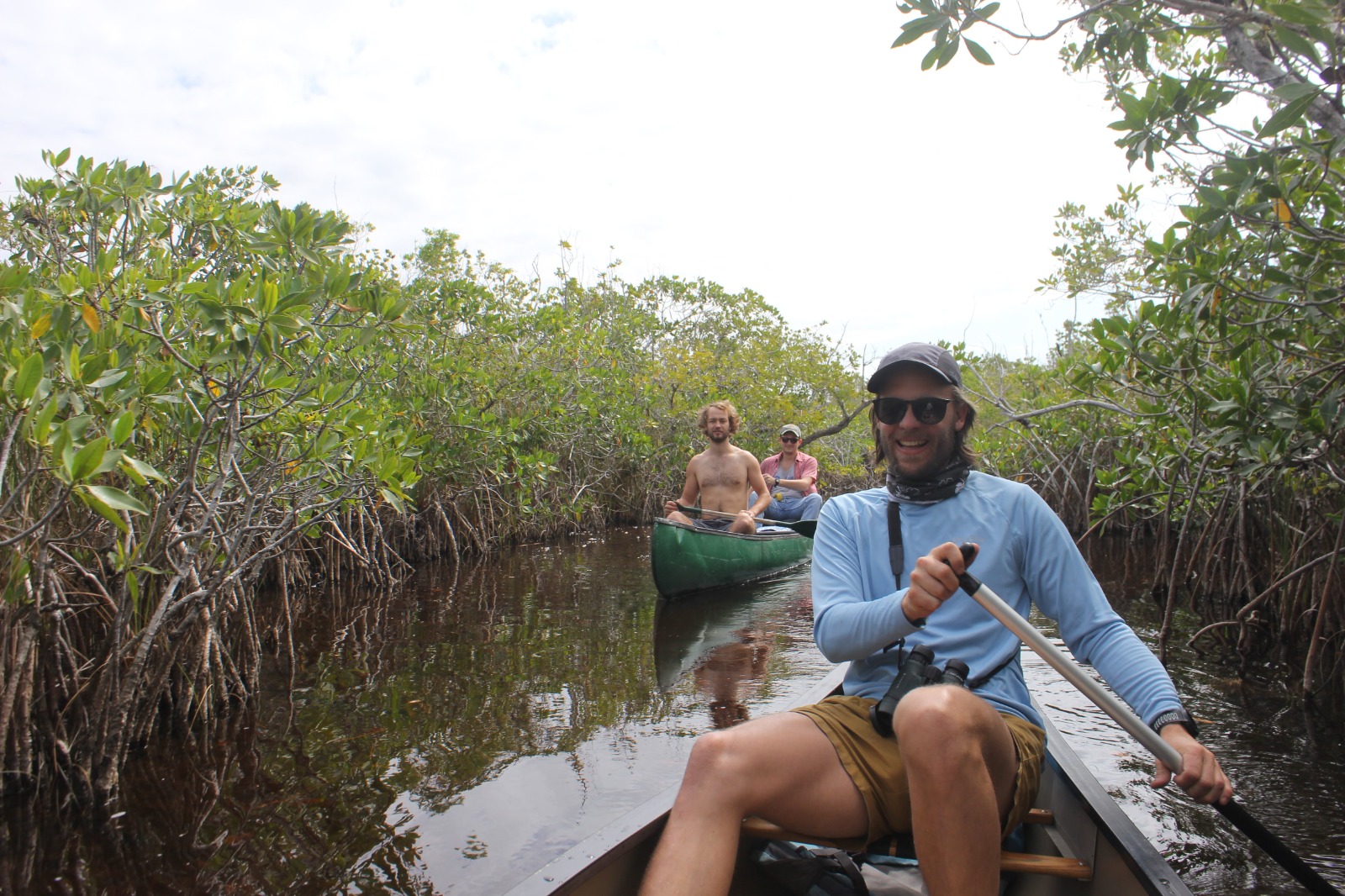 Jesse leading a group through mangroves by canoe on a field expedition