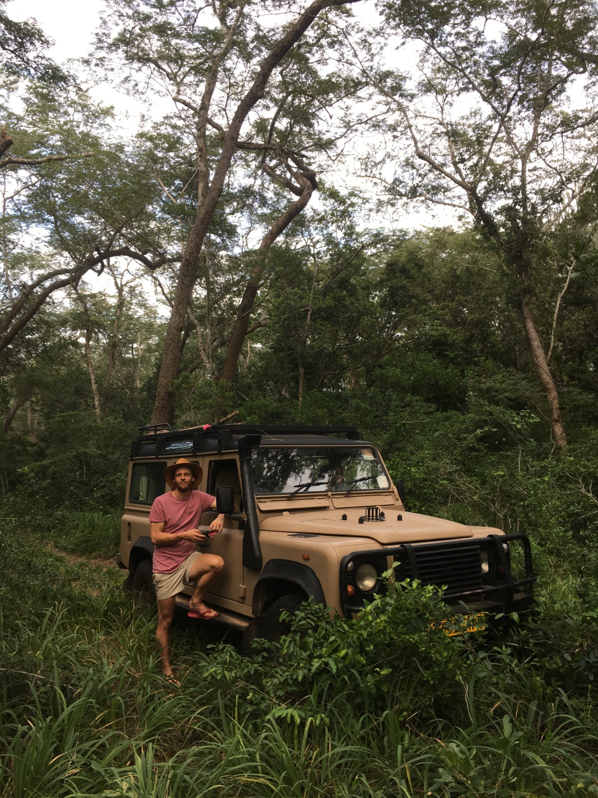 Jesse leaning against a Land Rover Defender deep in the bush of northern Tanzania