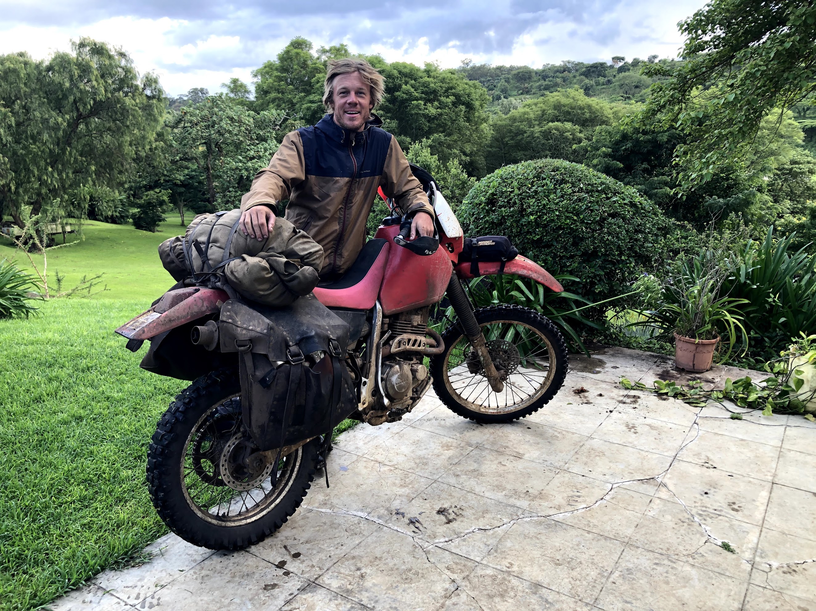 Trevor Borden arriving on a loaded dirt motorcycle after crossing East Africa